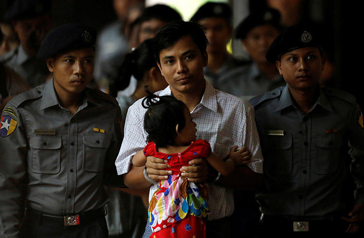 Handcuffed Reuters journalist Kyaw Soe Oo carries his daughter while arriving for a court hearing in Yangon, Myanmar on May 2. Kyaw Soe Oo and his colleague Wa Lone were reporting on a massacre in Rakhine state at the time of their arrest in December. (Reuters/Ann Wang)