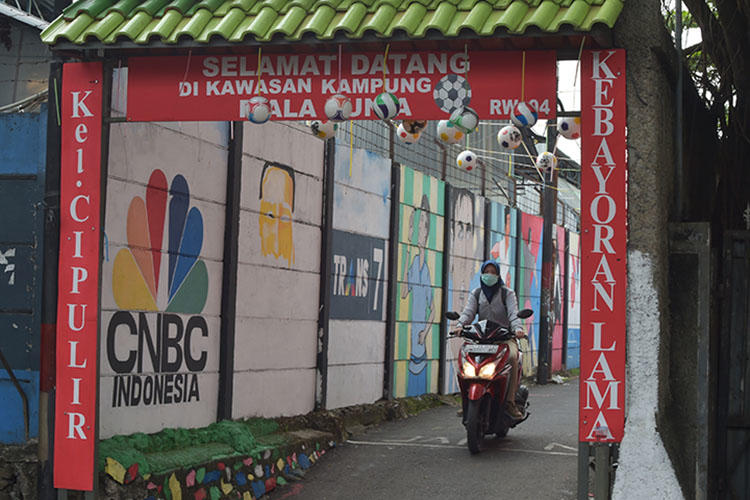 A motorcyclist rides down an alley in Jakarta in June. An Indonesian journalist died while in custody in South Kalimantan. (AFP/Adek Berry)