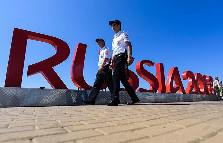 Security personnel walk near the Fisht Olympic Stadium in Sochi on June 12, 2018, two days ahead of the Russia 2018 World Cup football tournament. An imprisoned Russian editor was wounded and hospitalized in Sochi on June 18. (AFP/Jewel Samad)
