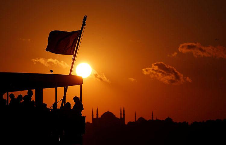 People on a ferry travel across the Bosphorus as the sun sets over the old city in Istanbul, Turkey on July 14, 2018. The Turkish government continues to crackdown on the press over two years after a failed coup attempt, according to reports. (Reuters/Murad Sezer)