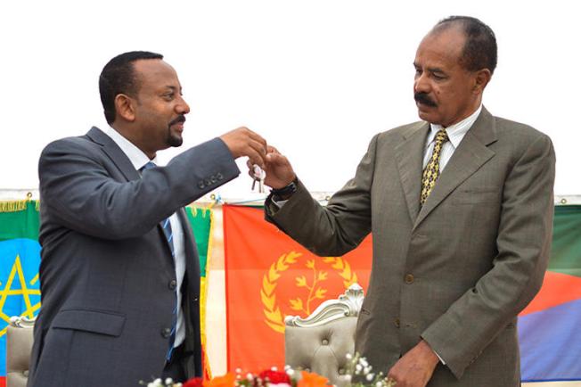 Ethiopian Prime Minister Abiy Ahmed, left, and Eritrean President Isaias Afwerki celebrate the reopening of the Embassy of Eritrea in Addis Ababa on July 16. An Ethiopian news crew was attacked and their driver killed while traveling to the capital to cover the visit. (AFP/Michael Tewelde)