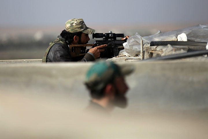 Rebel fighters stand at a lookout point, west of Manbij city, in the Aleppo Governorate in Syria on March 9, 2017. A group of journalists had planned to film a report in the nearby village of Al-Hoshiriya about a June 4 agreement between the U.S. and Turkey on the full withdrawal of Syrian Kurdish People's Protection Units (YPG) from Mambij, a main hub in the area, when they were detained by an FSA brigade, according to reports. (Reuters/Khalil Ashawi)