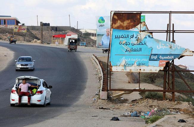 A man sits in a car trunk in Gaza City in July 2018. Israel has banned the Hamas-affiliated Al-Quds TV from operating in the region. (Reuters/ Marius Bosch)