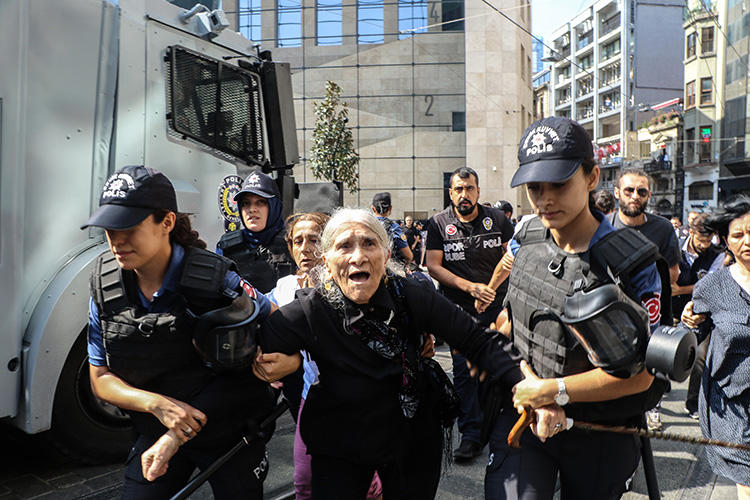 Riot police detain Emine Ocak, a member of Saturday Mothers group, during a demonstration on August 25, 2018, in Istanbul. Turkish police assaulted reporters at the August 25 protest. (AFP/Hayri Tunc)