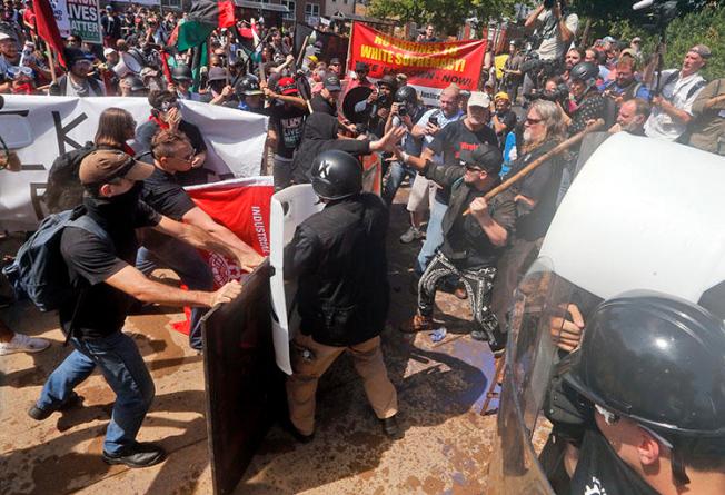 White nationalist demonstrators clash with counter-demonstrators at the entrance to Lee Park in Charlottesville, Virginia, on August 12, 2017. A Unite the Right rally is planned in Washington, D.C., on the one-year anniversary of the Charlottesville demonstrations. (AP Photo/Steve Helber)