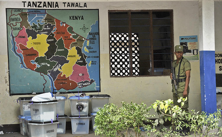 Tanzanian police stand guard outside a vote counting center at a school in Dar es Salaam, Tanzania, on October 28, 2015. On August 16, 2018, CPJ joined a call for the UN Human Rights Council to address a crackdown on free expression and other rights in Tanzania. (AP Photo/Khalfan Said)