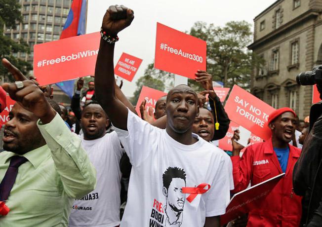 Supporters of a jailed Ugandan lawmaker known as Bobi Wine protest outside the country's embassy in Nairobi, Kenya, on August 23. A Ugandan radio show host was detained overnight after his show broadcast a discussion on the lawmaker's arrest and recent protests. (AP/Khalil Senosi)