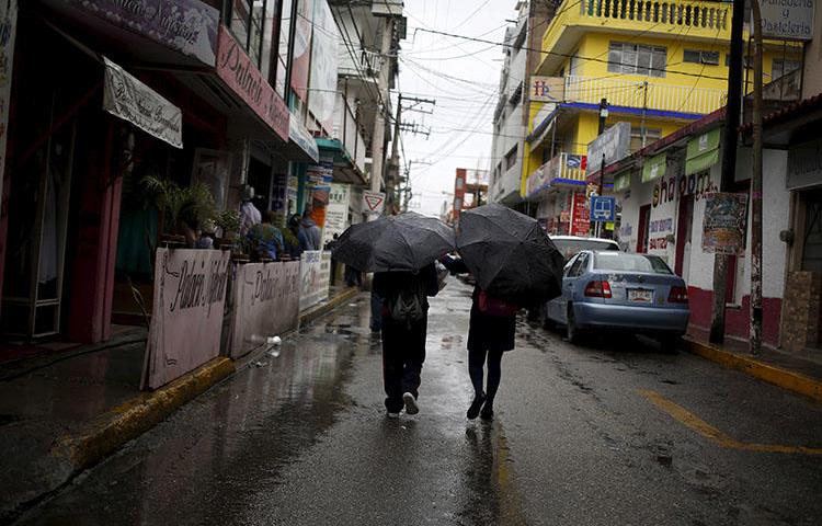 Two people walking in downtown Chilpancingo, in the Mexican state of Guerrero in September 2015. The office of Mexico's Federal Attorney General (PGR) on July 11, 2018, sent an email to the news website Quadratin summoning one of its reporters, Jorge Octavio Vargas Sandoval, for an interview at its regional office in Chilpancingo. (Reuters/Jorge Dan Lopez)