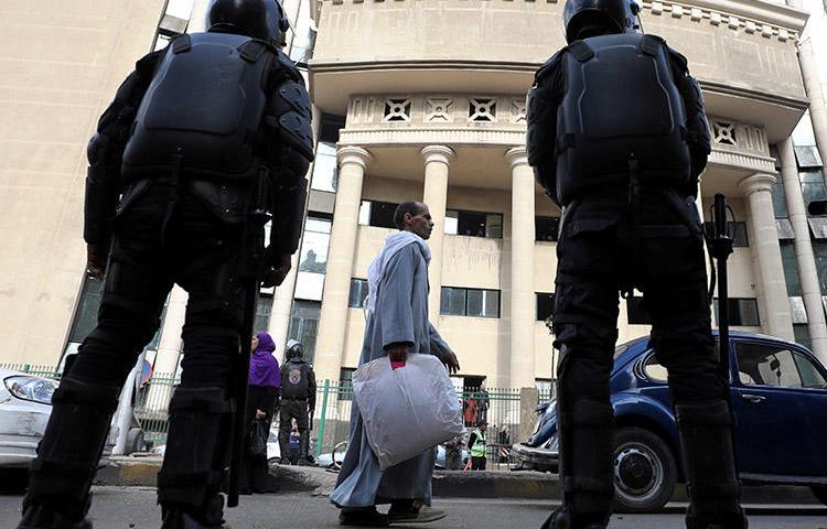 Egyptian security forces stand guard outside a Cairo court during a high-profile trial in January 2018. Prosecutors in August ordered four journalists to be detained on charges of false news and belonging to a banned group. (Reuters/Mohamed Abd El Ghany)