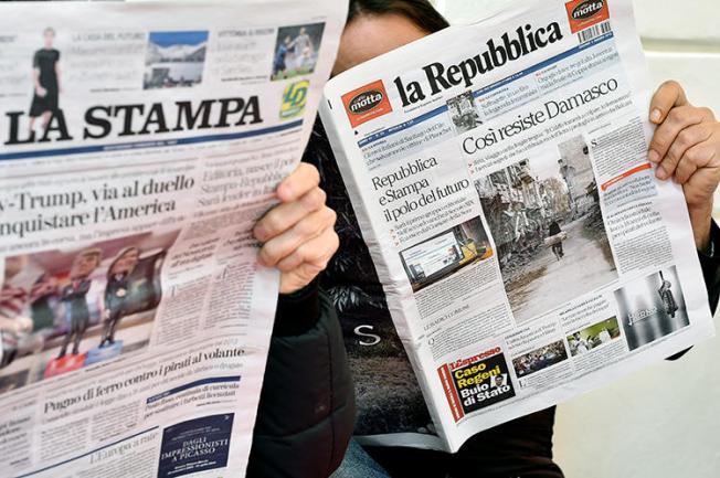 Customers read Italian dailies La Repubblica and La Stampa in Rome on March 3, 2016. Italian police searched a La Repubblica journalist's home and seized electronic devices on September 13, 2018, in Palermo. (AFP/Gabriel Bouys)