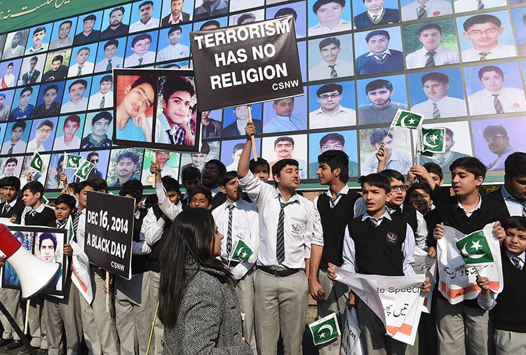 Students and activists gather by images of the victims of the 2014 Peshawar school massacre. A military crackdown after the attack helped reduce violence against the press, but increased self-censorship, journalists say. (AFP/Arif Ali)