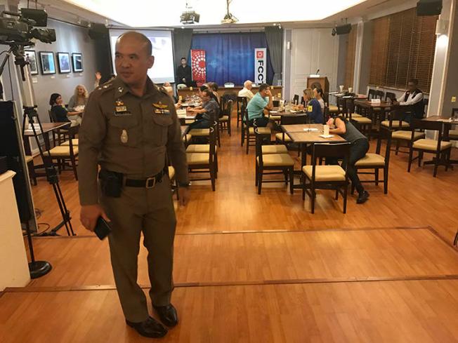 A Thai policeman stands inside the Foreign Correspondents' Club of Thailand on September 10, 2018, during a forum to discuss alleged human rights abuses by the military junta in Myanmar. The discussion was shut down by the Thai authorities. (AP Photo/Tassanee Vejpongsa)