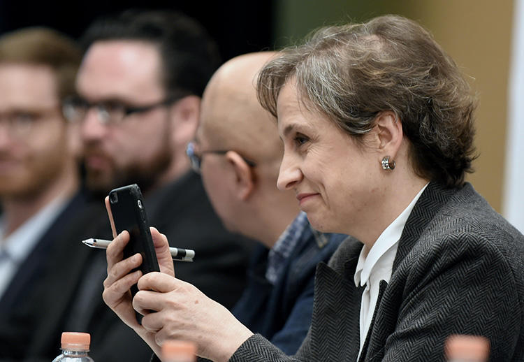 A jornalista mexicana Carmen Aristegui segura seu celular durante uma coletiva de imprensa na Cidade do México em 2017 sobre os governos que usam spyware para atacar jornalistas. (AFP/Alfredo Estrella)