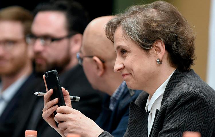 La journaliste mexicaine Carmen Aristegui tient son téléphone portable lors d'une conférence de presse à Mexico en 2017 sur les gouvernements qui utilisent les logiciels espions pour cibler les journalistes. (AFP/Alfredo Estrella) Mexican journalist Carmen Aristegui holds her mobile phone during a press conference in Mexico City in 2017 about governments using spyware to target journalist. (AFP/Alfredo Estrella)