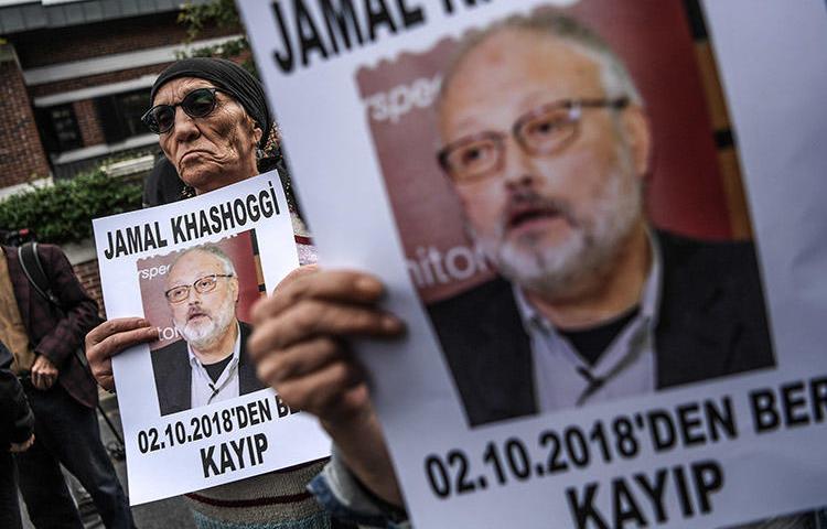 In an October 9 file photo, protesters outside the Saudi consulate in Istanbul hold portraits of critical Saudi journalist Jamal Khashoggi. Saudi Arabia today said the journalist was killed during a fight in the consulate. (AFP/Ozan Kose)