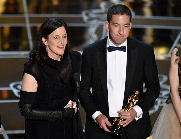 Filmmaker Laura Poitras and journalist Glenn Greenwald receive the Oscar for best documentary, for their film Citzenfour in February 2015. Poitras says repeated border stops led to her editing the film outside of the U.S. (AP/ John Shearer/Invision)