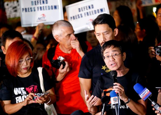 Maria Ressa, right, CEO of Rappler, an online news agency, addresses a rally of journalists and supporters during a protest against the Securities and Exchange Commission's order to revoke its registration on January 19, 2018, northeast of Manila, Philippines. Philippine authorities in November 2018 threatened to charge Ressa and Rappler with tax evasion. (AP Photo/Bullit Marquez)