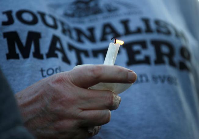 A member of the Capital Gazette takes part in a candlelight vigil near the newspaper's office on June 29. Several local newsrooms are reassessing security after the deadly attack. (Reuters/Leah Millis)