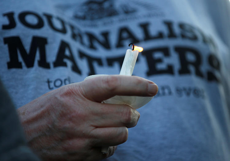 A member of the Capital Gazette takes part in a candlelight vigil near the newspaper's office on June 29. Several local newsrooms are reassessing security after the deadly attack. (Reuters/Leah Millis)