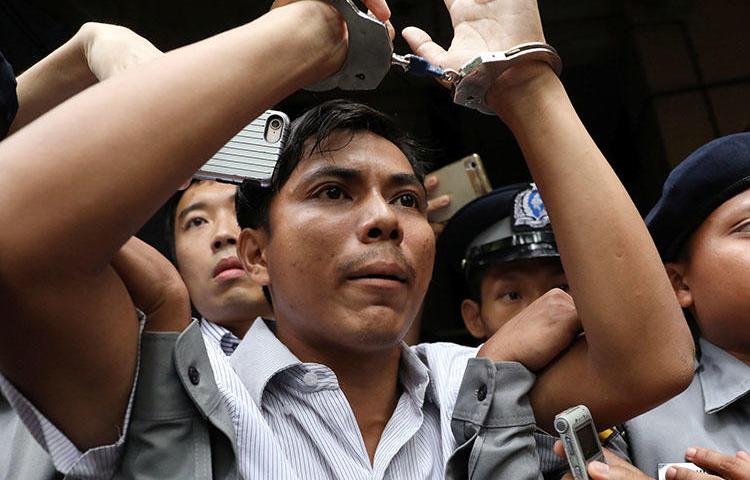 O jornalista da Reuters, Kyaw Soe Oo, é levado algemado de um tribunal em Yangon em setembro. Ele e seu colega Wa Lone estão cumprindo penas de sete anos de prisão em Mianmar. (Reuters / Ann Wang)