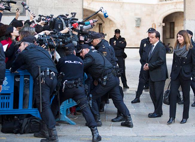 Agentes policiales se ubican entre periodistas y la procuradora pública española en las afueras de los tribunales de Palma de Mallorca, en la isla de Mallorca en febrero 2017. En diciembre 2018, agentes policiales confiscaron equipos y documentos de dos agencias de noticias en conexión con una investigación sobre información filtrada. (Jaime Reina/AFP)