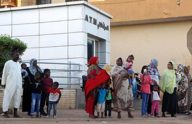 Residents stand outside an automated teller machine in Khartoum, Sudan, on November 8, 2018. Authorities in December declared a state of emergency in several cities due to anti-inflation protests. (Reuters/Mohamed Nureldin Abdallah)