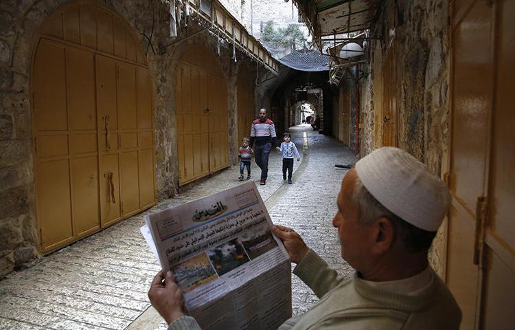 A Palestinian man reads a newspaper on March 31, 2018. A reporter for the London-based Quds Press News Agency, Yousef al-Faqeeh, was recently detained in the West Bank. (Hazem Bader/AFP)