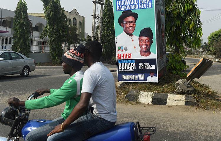 A campaign poster for Nigeria's incumbent president and candidate Muhammadu Buhari and his Vice-President Yemi Osinbajo, pictured in Lagos, on January 4. At least three journalists were injured by stray bullets after a fight broke out at a campaign rally for the ruling APC party. (AFP/Pius Utomi Ekpei)