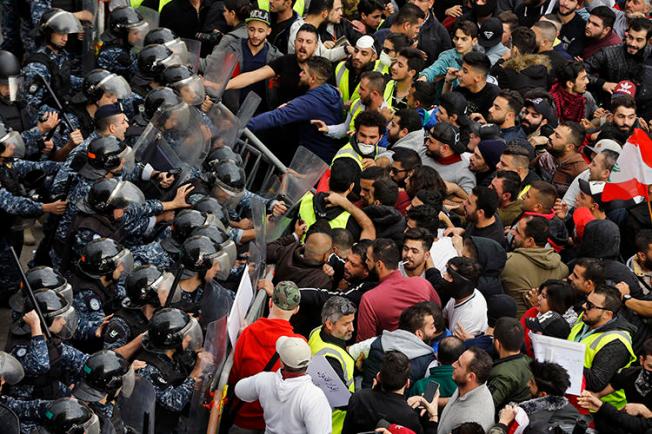 Anti-government protesters clash with riot police in central Beirut, Lebanon, on December 23, 2018. Multiple reporters were harassed and assaulted while covering the protests. (AP/Bilal Hussein)