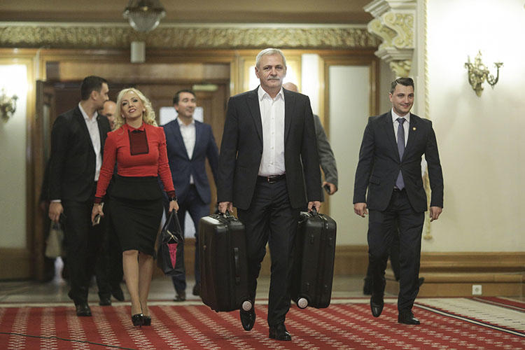 President of the ruling party Liviu Dragnea carries suitcases into parliament in November, as part of stunt mocking the Rise Project reporting. Romania's data protection authority has ordered the investigative outlet to reveal its sources. (Inquam Photos/Octav Ganea)