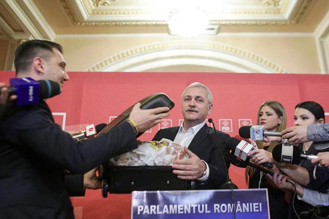 In response to a Rise Project report alleging corruption, based on documents provided in a suitcase, party leader Liviu Dragnea carried a case of donuts into parliament, which he said were from the investigative outlet. (Inquam Photos/Octav Ganea)