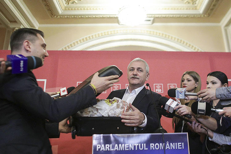 In response to a Rise Project report alleging corruption, based on documents provided in a suitcase, party leader Liviu Dragnea carried a case of donuts into parliament, which he said were from the investigative outlet. (Inquam Photos/Octav Ganea)