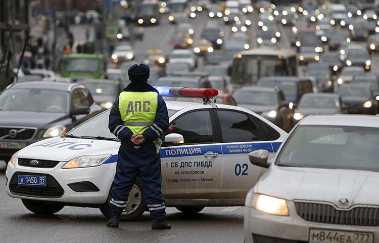 A Russian traffic police officer stands guard as vehicles drive past in central Moscow. In Far Eastern Russia, a blogger was recently detained by authorities, ostensibly for a traffic violation. He maintains that the arrest is linked to a video he shared online. (Sergei Karpukhin/Reuters)