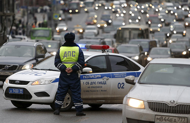 A Russian traffic police officer stands guard as vehicles drive past in central Moscow. In Far Eastern Russia, a blogger was recently detained by authorities, ostensibly for a traffic violation. He maintains that the arrest is linked to a video he shared online. (Sergei Karpukhin/Reuters)