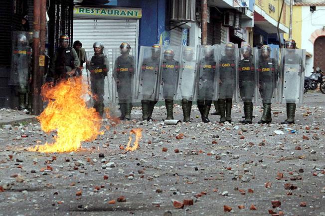 Security forces look on during clashes at a rally in Venezuela on January 24. Amid the political crisis and widespread protests, Venezuelan authorities have raided news outlets, detained journalists and confiscated equipment. (Reuters/Carlos Eduardo Ramirez)