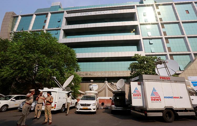 Police officials stand outside the Central Bureau of Investigation (CBI) headquarters in New Delhi, India, on October 26, 2018. The CBI today convicted four suspects in the 2002 murder of journalist Ram Chandler Chaterpatti. (Altaf Hussain/Reuters)