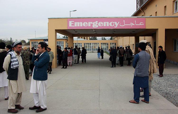 Afghan relatives of victims looks on as they stand in front of a hospital following a bomb attack in Taloqan in northeastern Takhar province on October 13, 2018. Two radio journalists were shot and killed in Taloqan on February 5, 2019. (AFP/Naseer Sadeq)