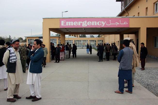 Afghan relatives of victims looks on as they stand in front of a hospital following a bomb attack in Taloqan in northeastern Takhar province on October 13, 2018. Two radio journalists were shot and killed in Taloqan on February 5, 2019. (AFP/Naseer Sadeq)