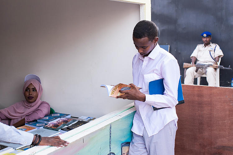 A young man looks through a book at the Hargeisa International Book Fair in the Somaliland capital of Hargeisa on July 21, 2018. Somaliland authorities recently issued a one-year suspension of the privately owned Foore newspaper. (Mustafa Saeed/AFP)