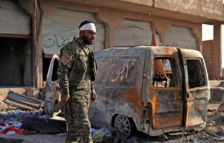 A Fighter from the Syrian Democratic Forces stands guard in the front line village of Baghouz on February 2, 2019. An Italian photojournalist was recently injured by Islamic State rebels while covering the conflict in Baghuz. (Delil Souleiman/AFP)