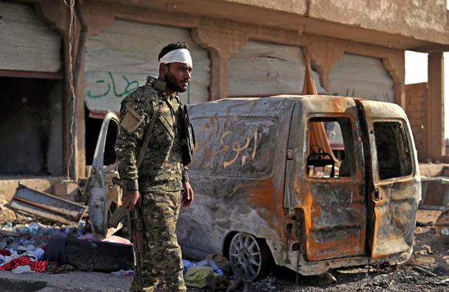 A Fighter from the Syrian Democratic Forces stands guard in the front line village of Baghouz on February 2, 2019. An Italian photojournalist was recently injured by Islamic State rebels while covering the conflict in Baghuz. (Delil Souleiman/AFP)