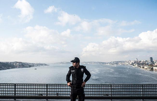 A police officer stands guard on a bridge during the 2018 Istanbul marathon. Two journalists were detained after separate raids in the city in February 2019. (AFP/Bulent Kilic)