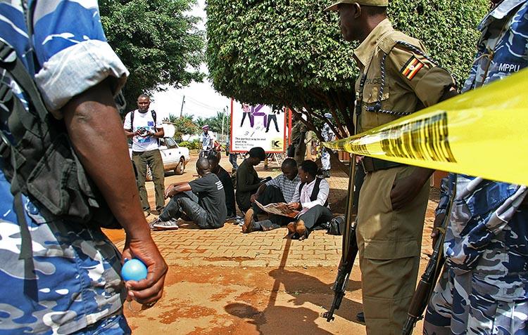 Ugandan journalists sit outside the office of the Daily Monitor, which was closed on May 20, 2013, by armed police. The Monitor's website was recently ordered to suspend publication over a regulatory dispute. (Isaac Kasamani/AFP)