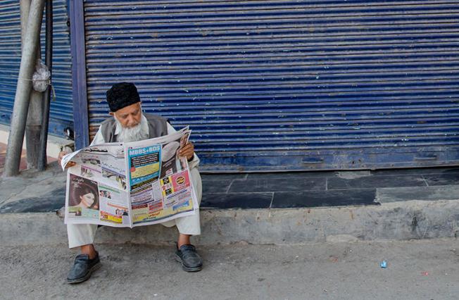 A Kashmiri man reads a newspaper in Srinagar on August 31, 2018. The Kashmiri state government recently removed lucrative advertising from two leading dailies in the region. (Dar Yasin/AP)