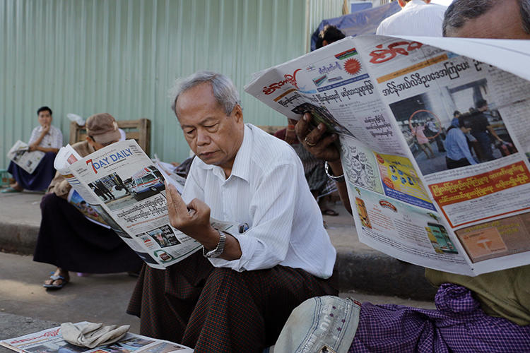 People read local newspapers in Yangon, Myanmar, on January 30, 2017. Two journalists working in Kachin stat were recently detained and assaulted by a local mining company there. (Thein Zaw/AP)