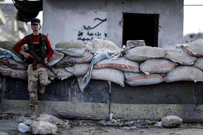 A Syrian opposition fighter stands at a checkpoint in Idlib province on October 13, 2018. A journalist was recently injured in Idlib while covering a government shelling campaign there. (Ugur Can/DHA via AP)