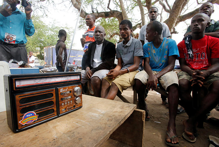 People listen to a radio in Monrovia, Liberia, on December 27, 2017. The Roots FM radio station in Monrovia was recently attacked in two separate incidents. (Thierry Gouegnon/Reuters)