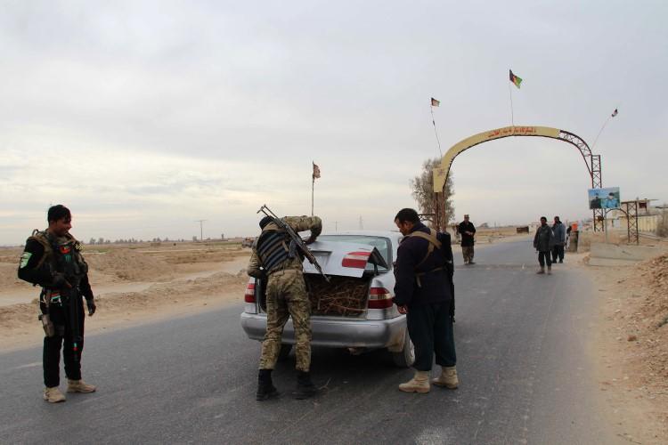 Afghan policemen search passengers at a checkpoint in Helmand province on December 17, 2017. A journalist in Helmand was recently injured by a car bomb in an assassination attempt. (Noor Mohammad/AFP)