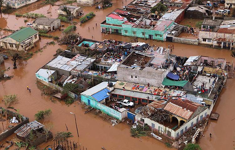 Moradores ficam em telhados em uma área inundada de Buzi, no centro de Moçambique, em 20 de março de 2019, após a passagem do ciclone Idai. (AFP/Adrien Barbier)