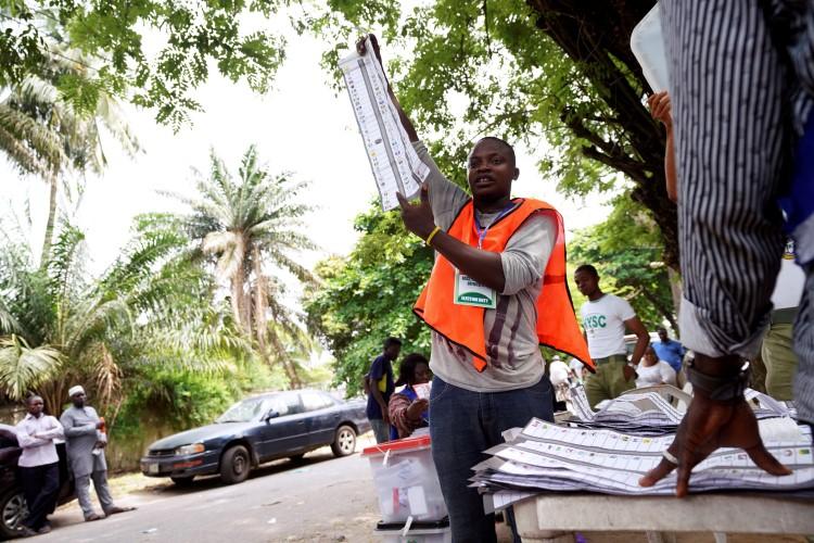 A man raises a ballot paper during the counting of governorship and state assembly election results in Lagos, Nigeria, on March 9, 2019. (Adelaja Temilade/Reuters)